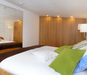 Doppelbett Spiegel und Kleiderschrank im Ferienhaus im Grünen nahe See bei Potsdam und Berlin