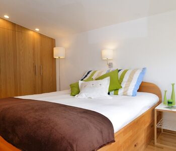 Doppelbett Spiegel und Kleiderschrank im Ferienhaus im Grünen nahe See bei Potsdam und Berlin